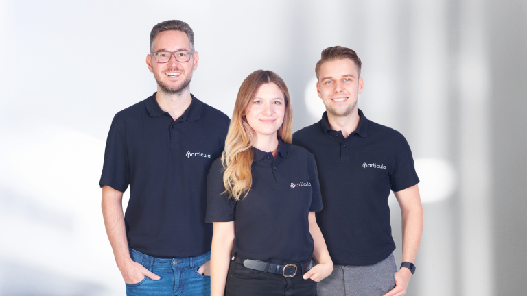 Founders of Particula - a risk rating and data analytics platform for digital assets - standing on a grey background with Carsten Hermann on the left, Nadine Wilke in the middle and Timm Reinsdorf on the right